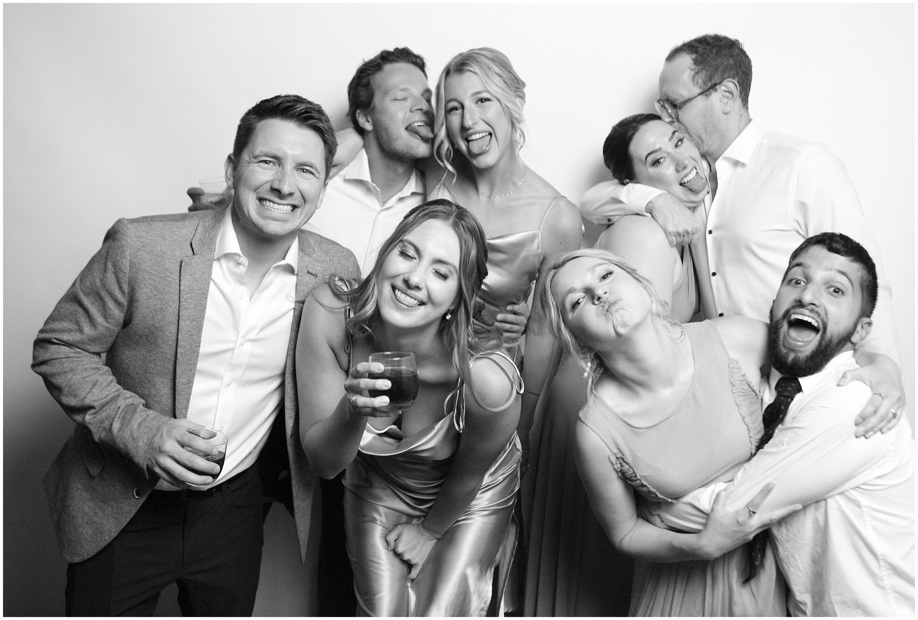 A joyful group of wedding guests pose together