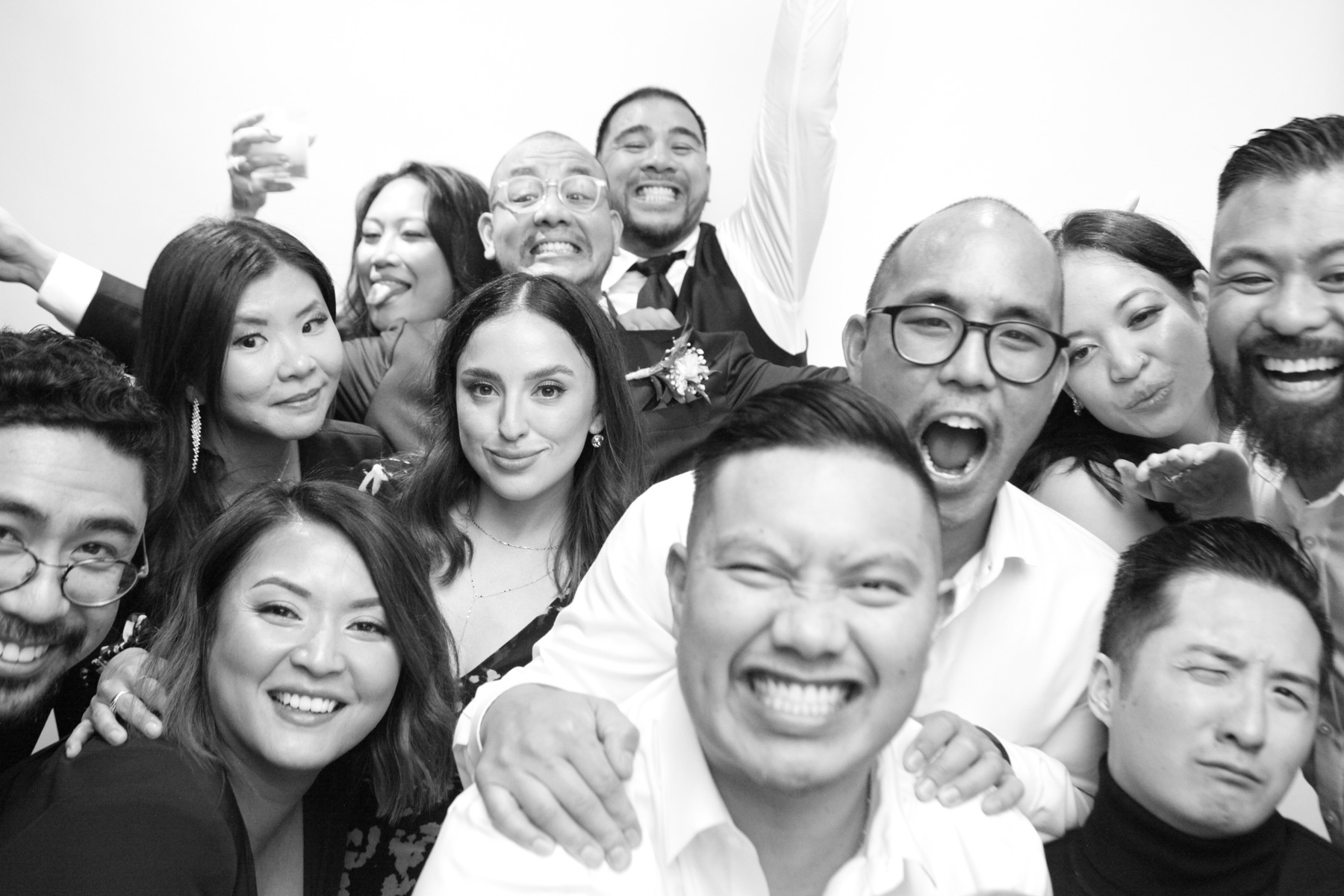 A large wedding group leans into the frame